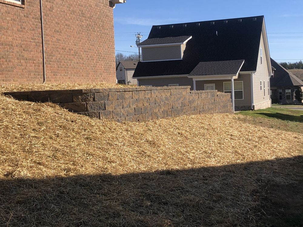 Retaining wall with newly seeded slope